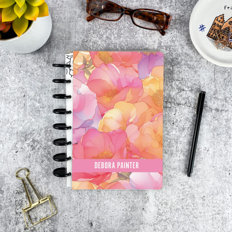 Personalized disc bound password book in orange and pink floral pattern with laminated cover, black discs, and custom name