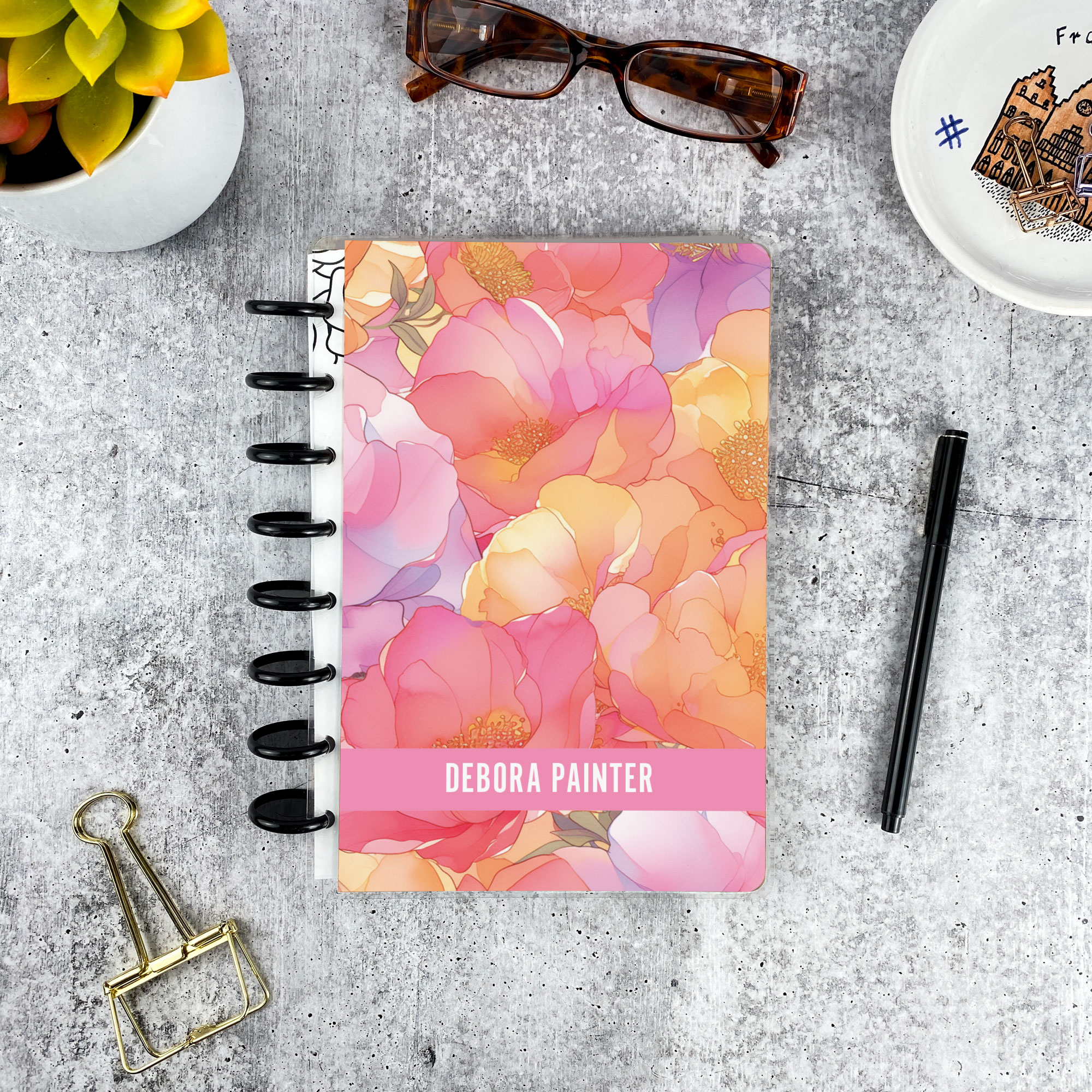 Personalized disc bound password book in orange and pink floral pattern with laminated cover, black discs, and custom name